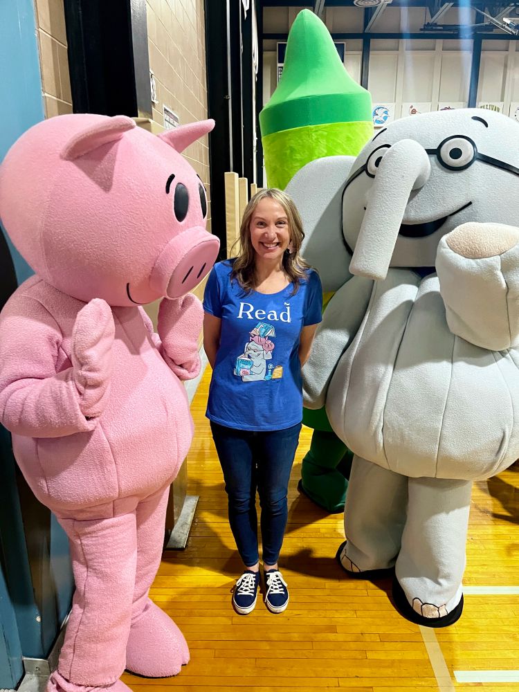 An author takes a photo with the iconic Mo Willems’ book characters Elephant and Piggie.