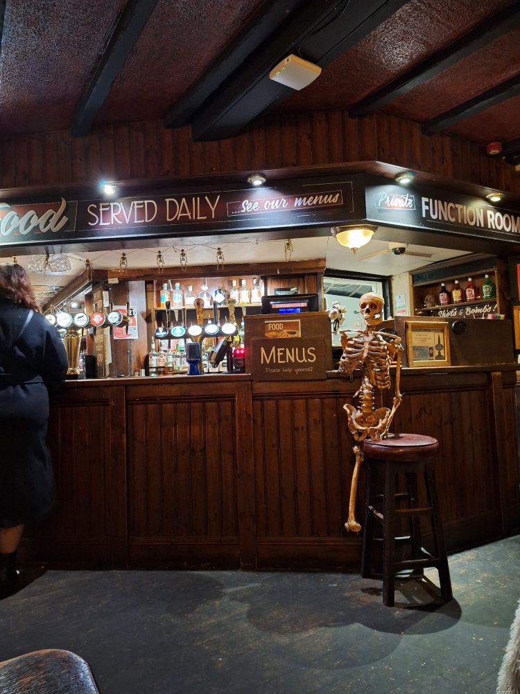 Interior, the back bar of the Golden Fleece Inn, York; the most haunted pub in the UK. There is a skeleton propped up at the bar.