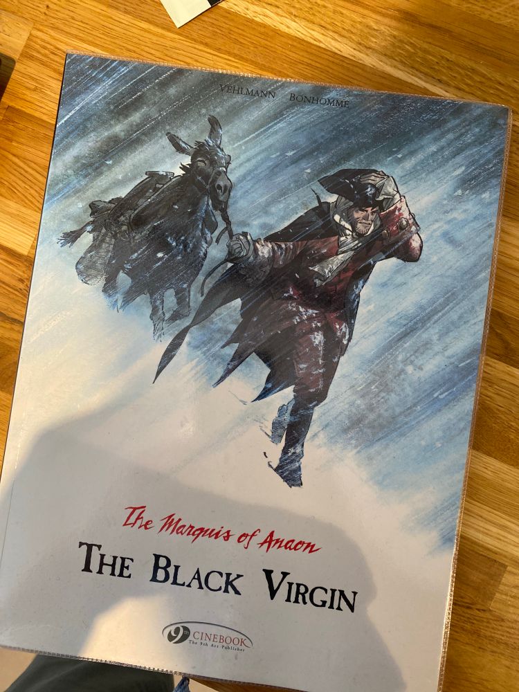 The Marquis of Anaon and donkey trudging through a blizzard on the cover of The Black Virgin, number 2 in The Marquis of Anaon series.