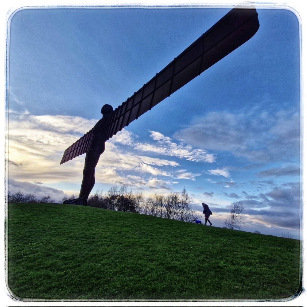 A dramatic skyline picture of the same silly pair running about the angel!