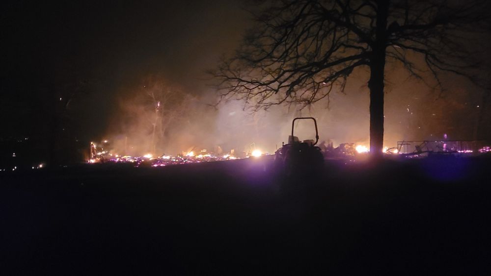 a fire burns on an area of land in the night