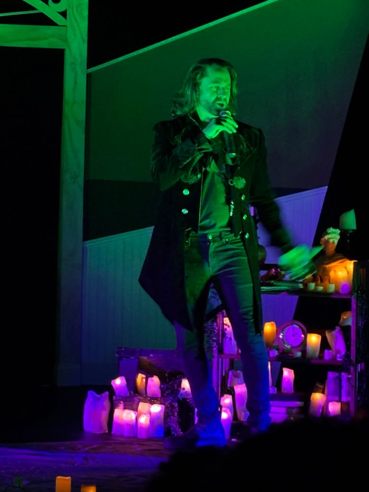 Actor bathed in green light reciting “The Fall Of The House Of Usher”