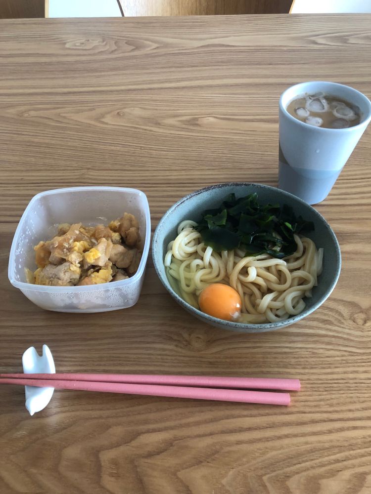 右上にコーヒー
右にわかめと生卵が乗ったうどん
左に保存容器に入った鶏肉と卵のいためもの
鳩の箸置きに乗ったピンクの箸