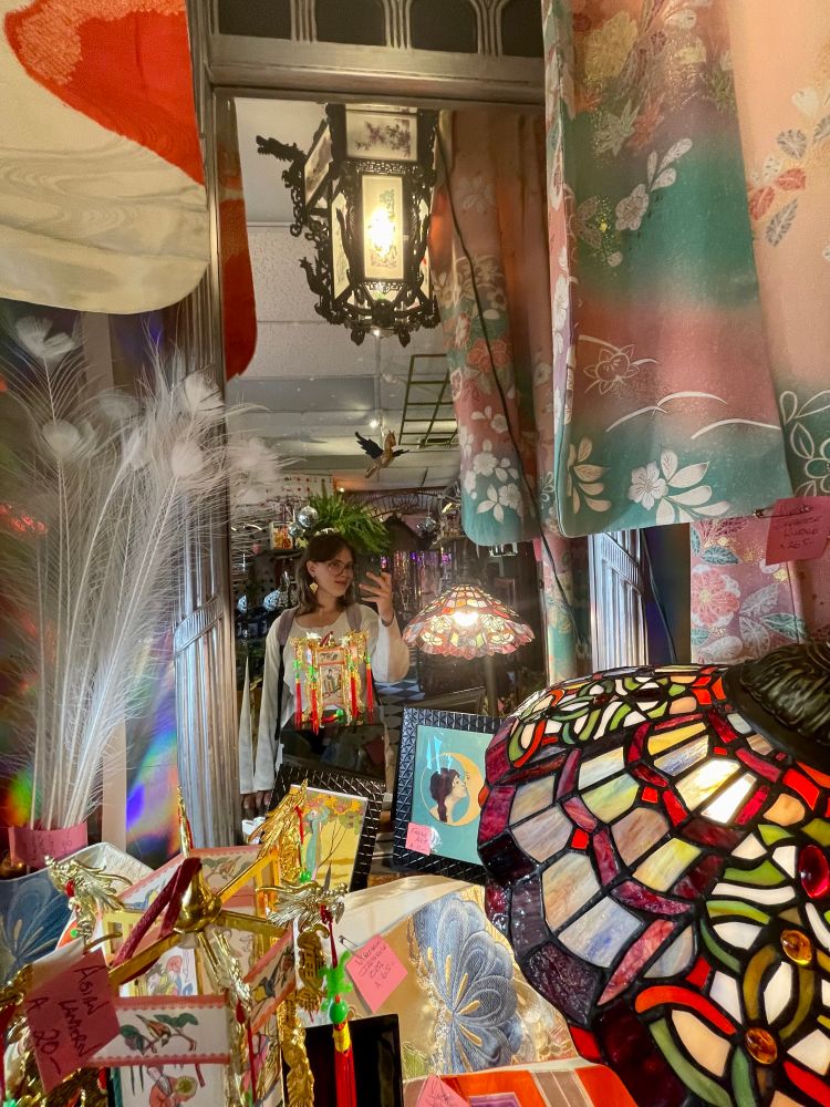Ivy takes a mirror selfie in an antique store
