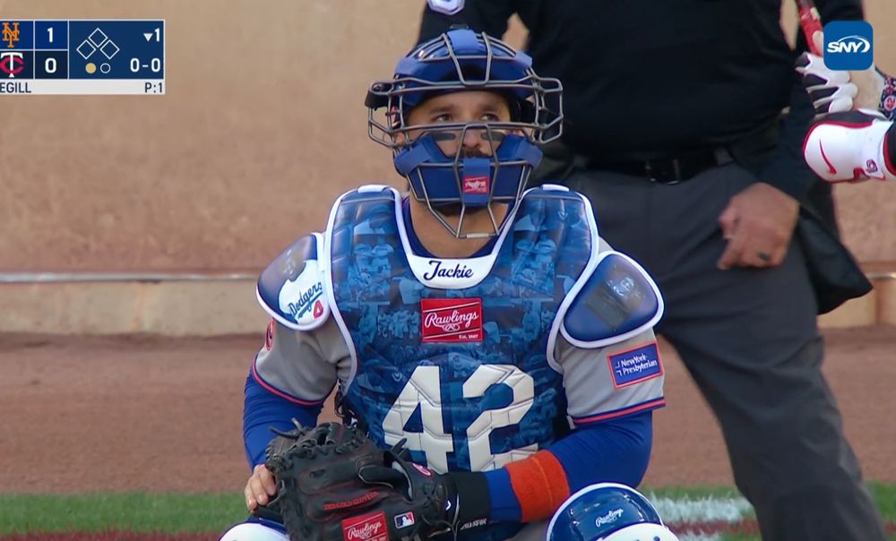 Luis Torrens wearing a chest protector that reads '42' with the name Jackie in script