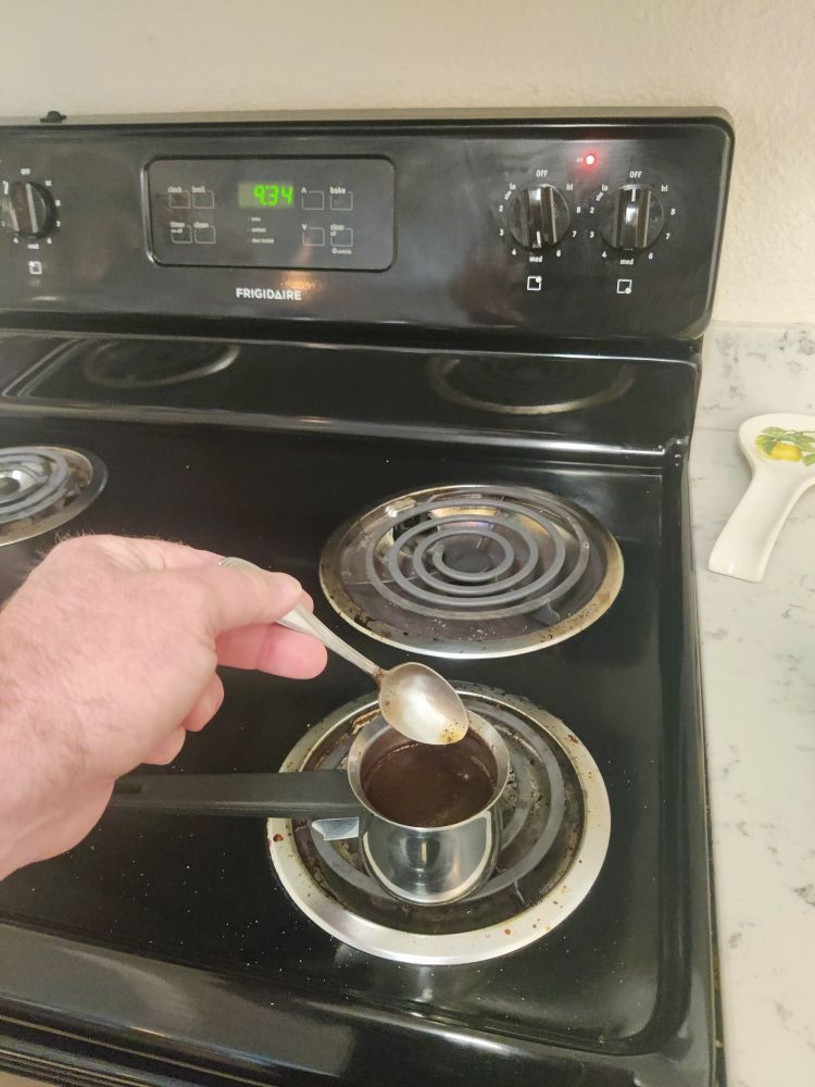 A picture of someone making trigger's coffee on an electric stove top. The cesve is on the wrong burner. 