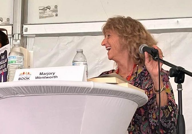 Marjory Wentworth smiling, holding a microphone.