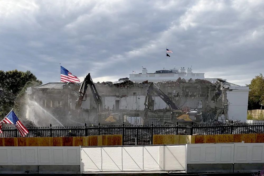 The East Wing of the White House almost totally destroyed with construction equipment in front of it and a barrier in front of them