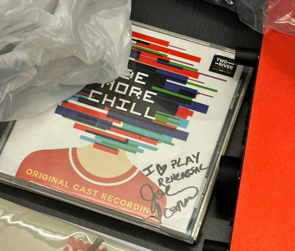 A CD of the original cast recording of “Be More Chill”, signed by the writer Joe Iconis with “I ❤️ Play Rehearsal”