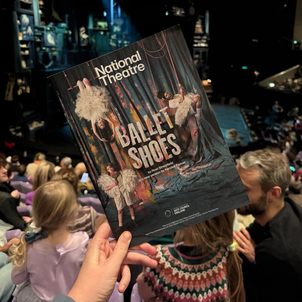 A new program of Ballet Shoes in front of a stage