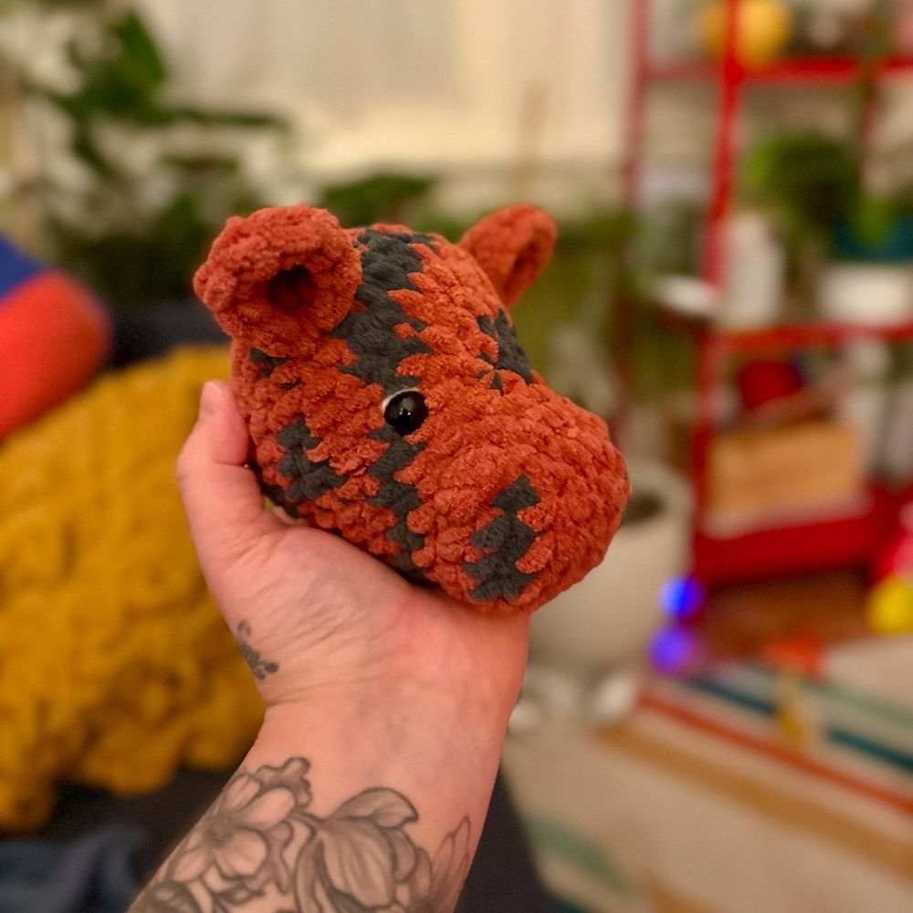 I’m holding Tigger’s crocheted head in my left hand. Tigger is made from rust red and coal blanket yarn.