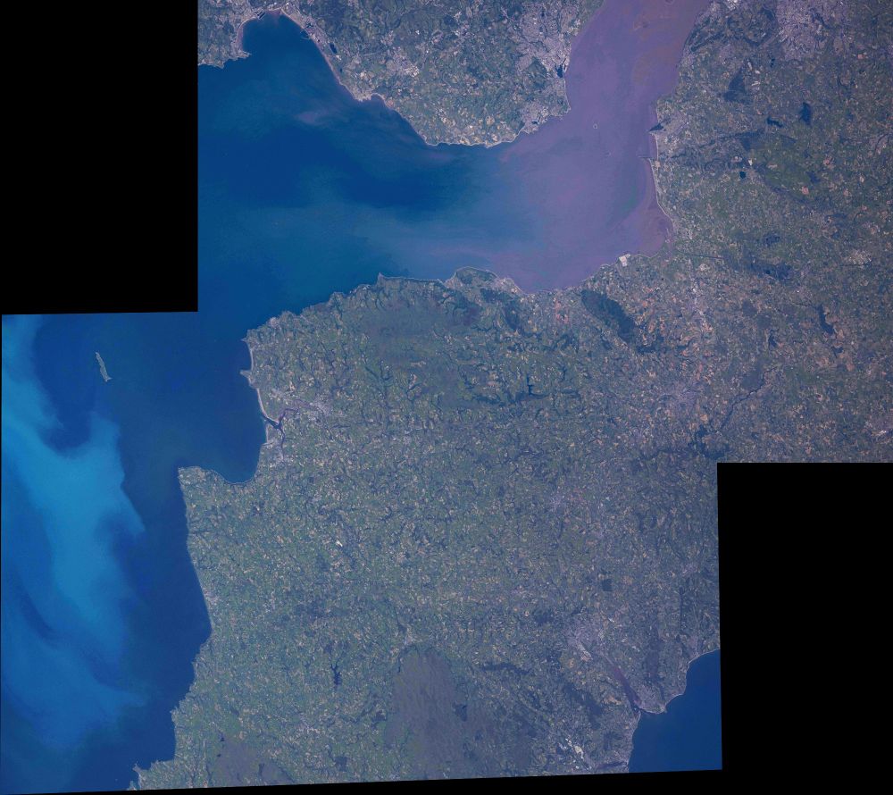The image is a stitch of images ISS073-E-250736 and 250737. Originals https://eol.jsc.nasa.gov/SearchPhotos/photo.pl?mission=ISS073&roll=E&frame=250736 and https://eol.jsc.nasa.gov/SearchPhotoshoto.pl?mission=ISS073&roll=E&frame=250737  We are looking at a parts of Somerset, Devon and Cornwall in the centre and bottom of the image and a part of the Severn estuary shown in the previous picture at top. The water in the estuary is brownish from sediment in the water, the sea at left is blue with light blue patches of algae. 