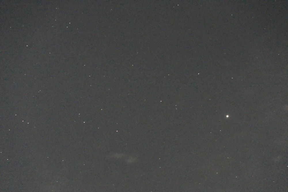 The image shows a starry sky which is not completely dark because of the full Moon. Planet Saturn kis visile as a bright dot at right.