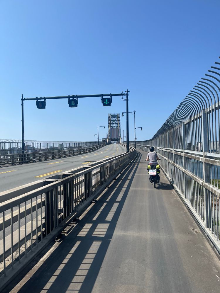 A view from the Macdonald bridge bikeway Halifax-bound. It’s a bright blue sky day. The vehicle lanes are empty.