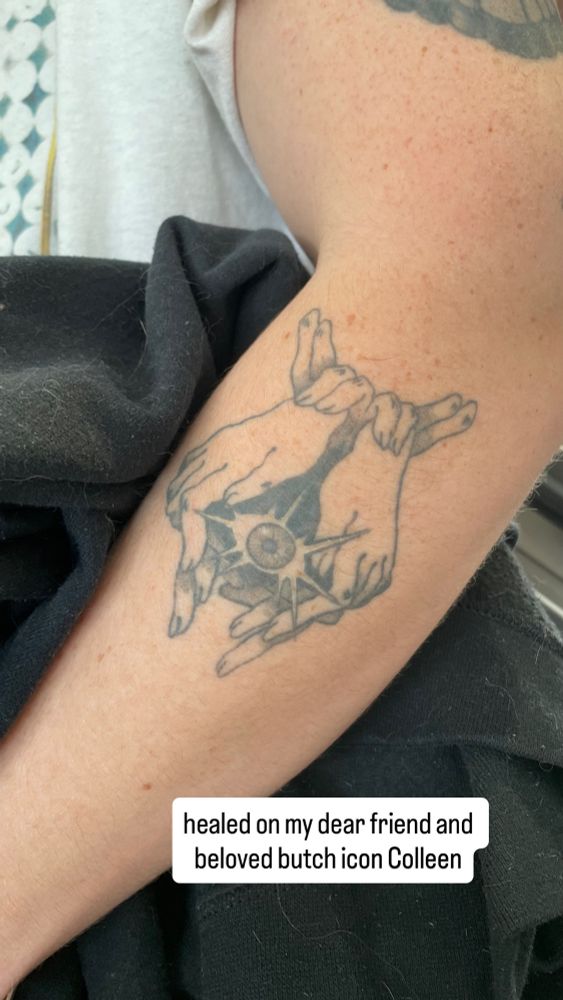 a healed tattoo of surrealistic hands and fingers cupping a shining eyeball