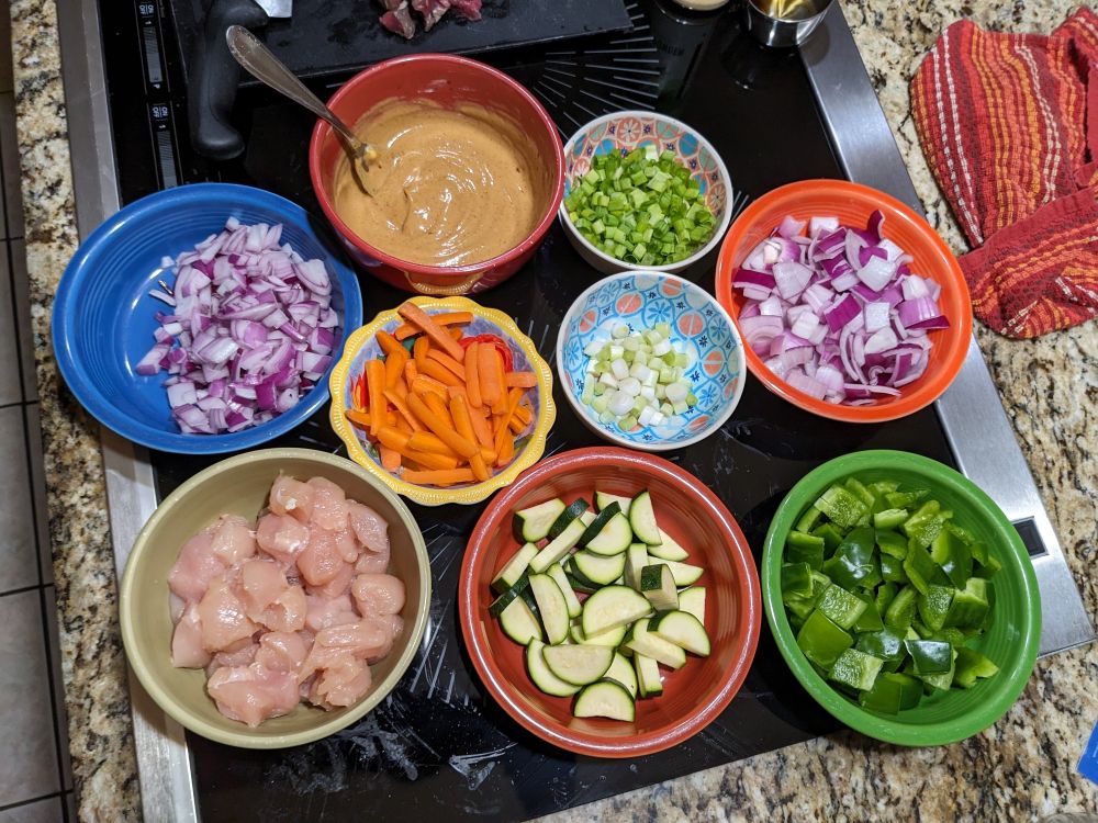 Large diced red onions, green bell peppers, zucchini, and carrots for sauteed veggies. Small diced red onions, scallions, and large diced chicken for fried rice. Bowl of mixed soy sauce, butter, and garlic powder for rice as well