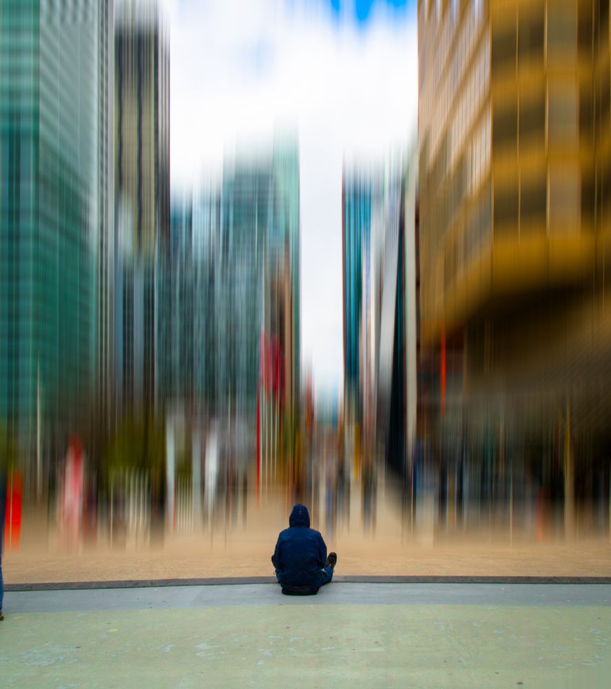 a man with his back to the camera looking at a blurred out city