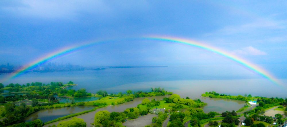 a rainbow against the backdrop of the toronto skyline
