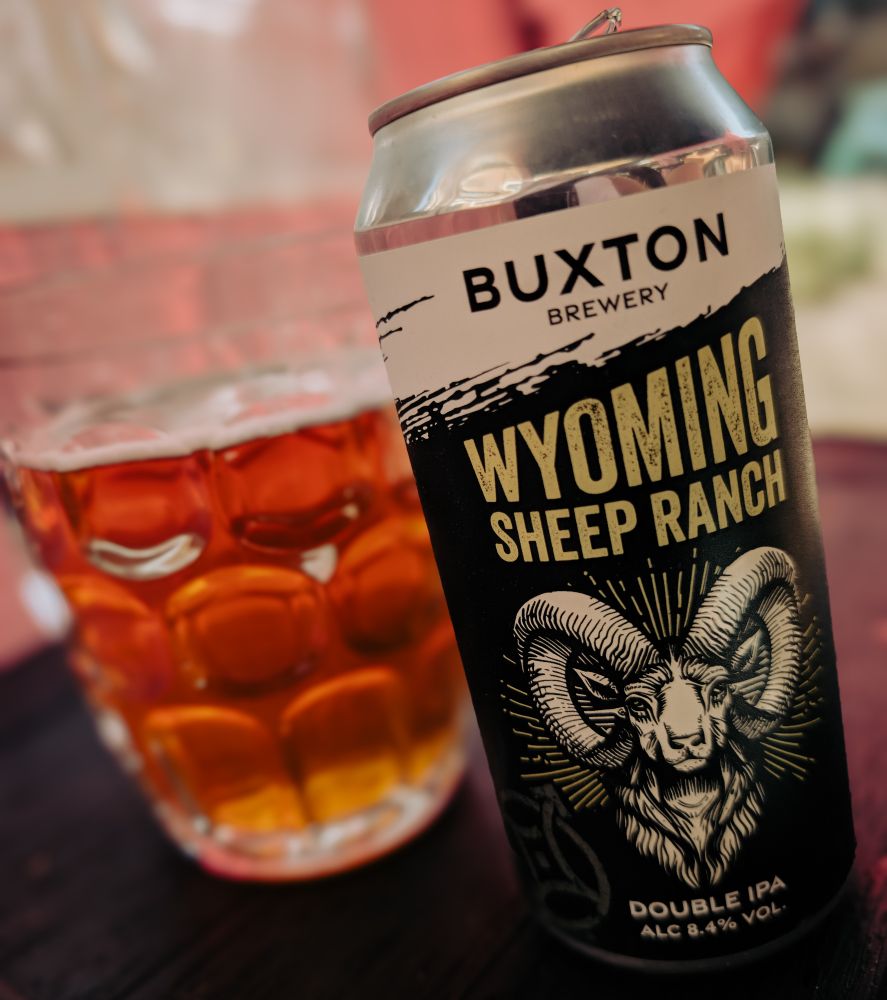 A tin of IPA next to a beer glass. Wyoming Sheep Ranch by the Buxton Brewery.