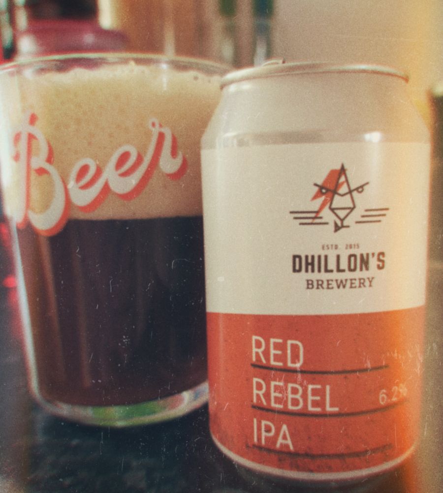 A tin of IPA next to a full glass of beer.