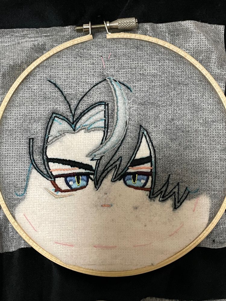 ゲーム「原神」のキャラ、リオセスリのぬいぐるみを作っている様子の画像です。瞳や眉毛、一部の髪の刺繍が済んでいます。