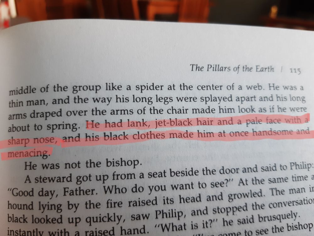 a page of the book Pillars of the Earth, with the following passage highlighted: "He had lank, jet-black hair and a pale face with a sharp nose, and his black clothes made him at once handsome and menacing."