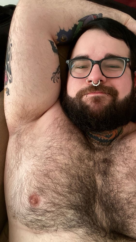 Laying on my bad with one arm up exposing my musky pit