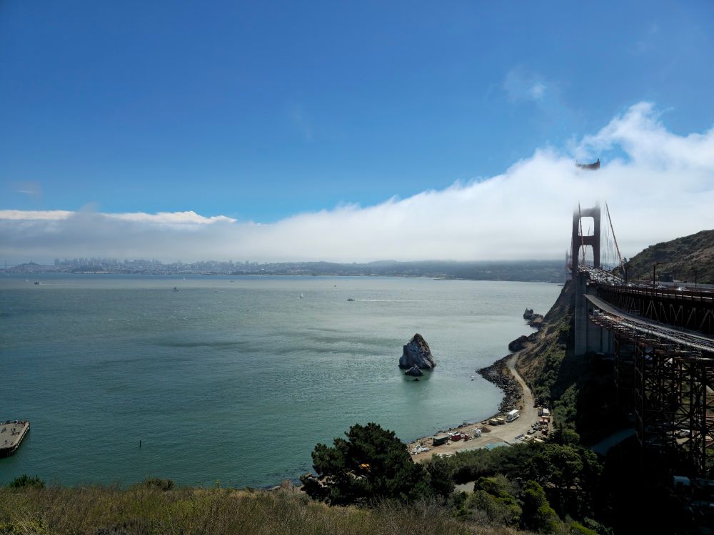 Photograph of the San Francisco bay. Fog resting on the upper half of the bridge and laying over the city