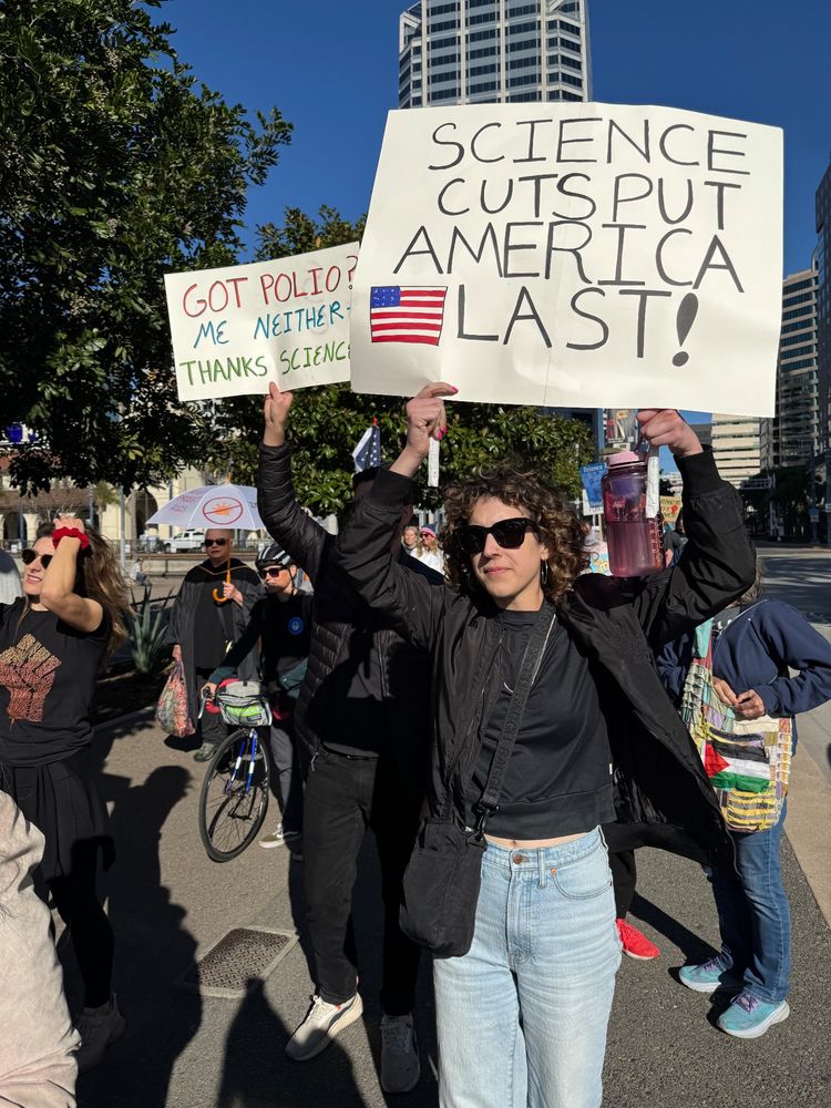 A human holding a sign in support of the NIH
