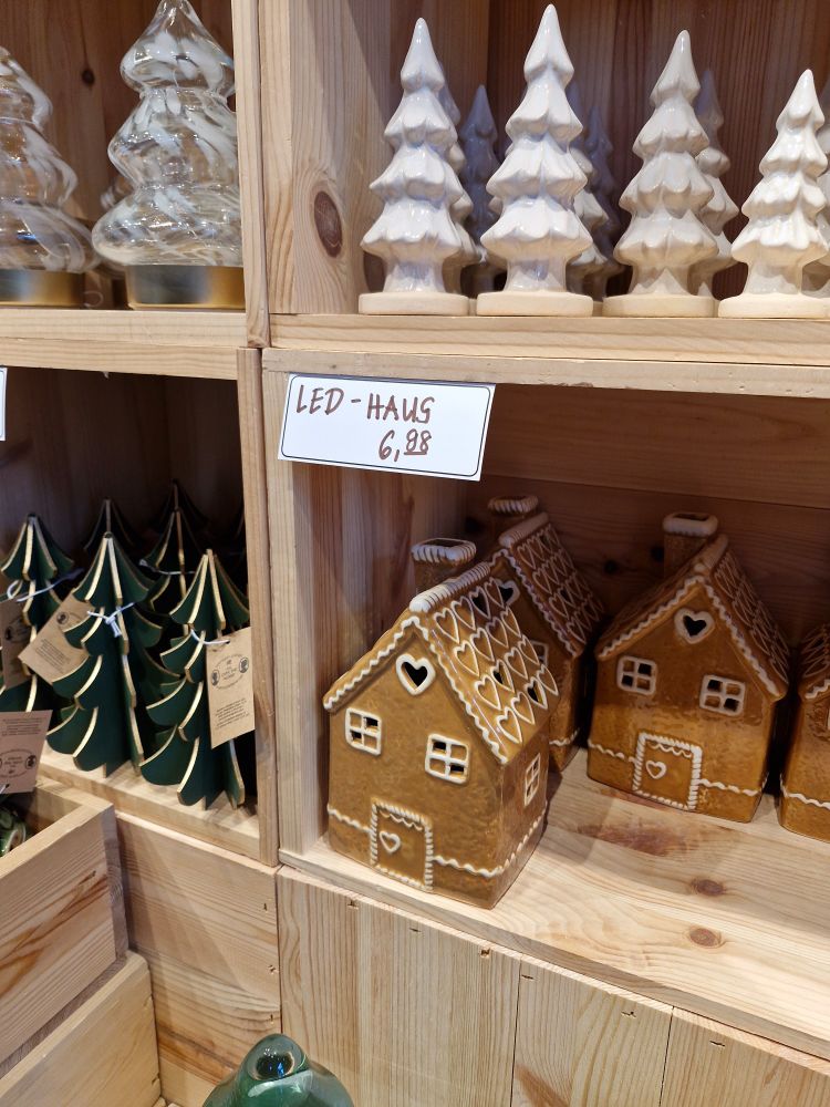 Ein Keramikhaus, das aussieht wie ein Lebkuchenhaus mit der Beschriftung "LED-HAUS 6,88"