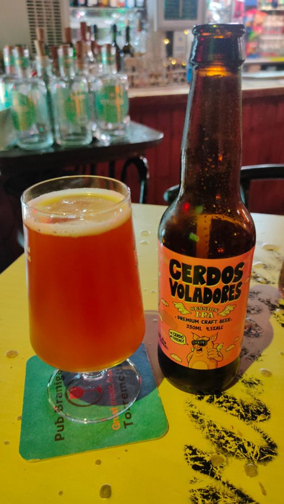 A bottle of Cerdos Voladores on a pub table. 