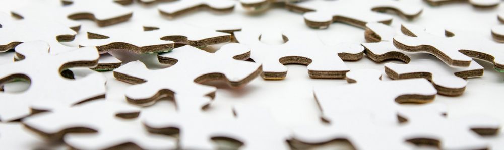 White jigsaw pieces scattered on a white surface