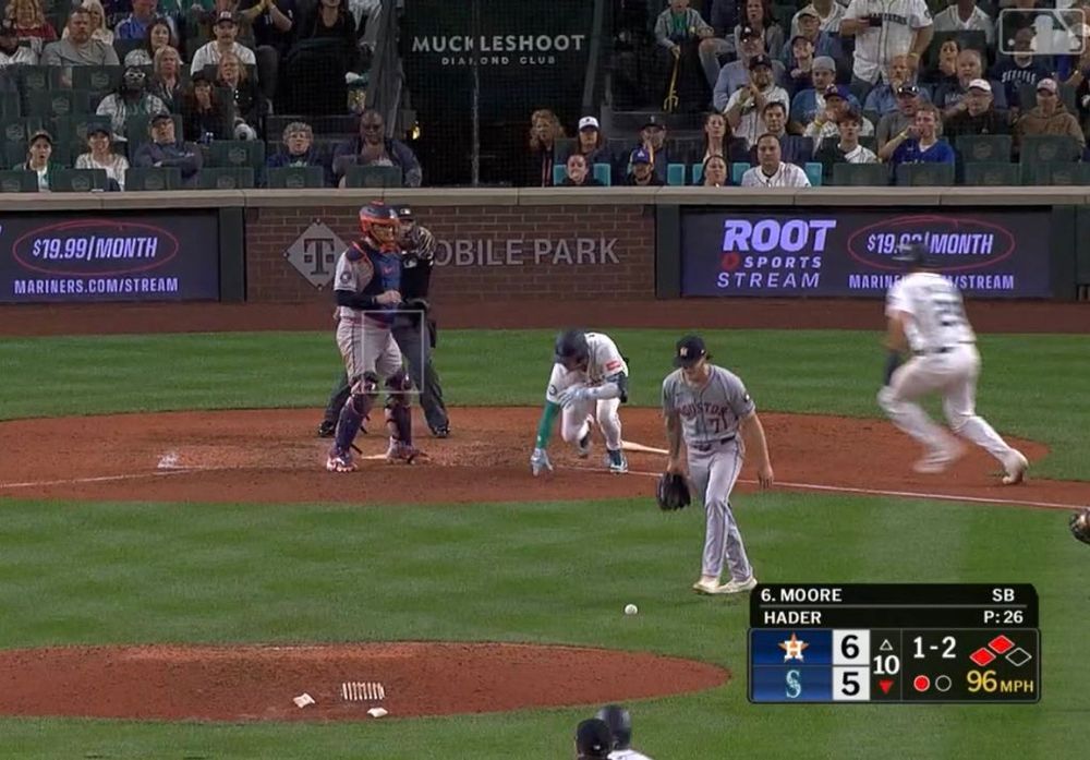 Dylan Moore crouched on the ground in pain as Cal Raleigh runs towards him and Josh Hader drops the baseball