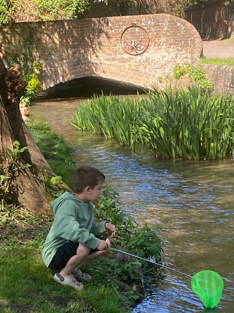 Small boy on stream bank with fishing net. Out on a crayfish rather than an Easter Egg hunt. 