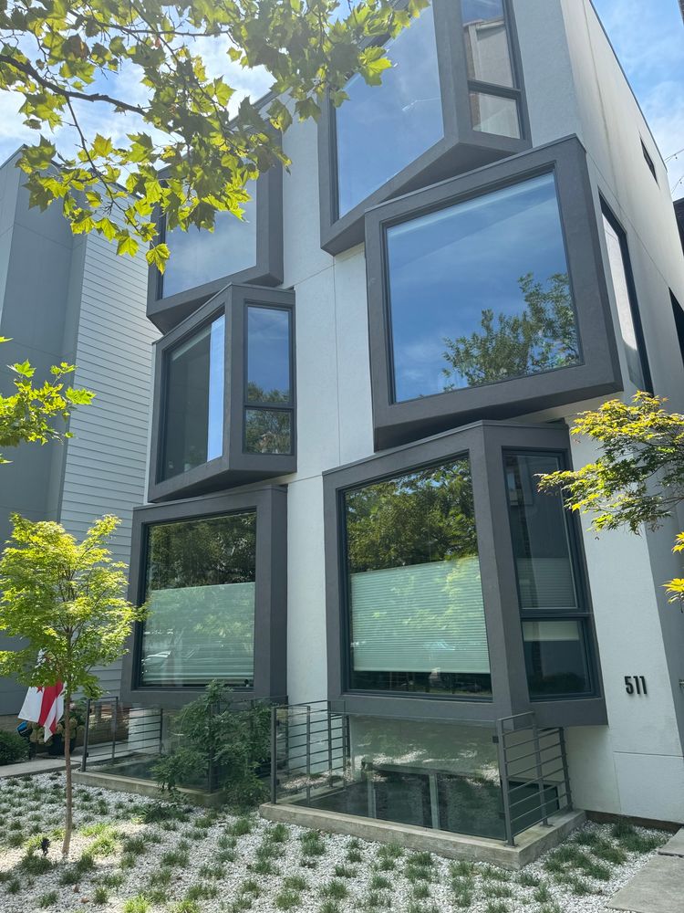 A picture of a four plex building with extremely odd shaped cubic windows