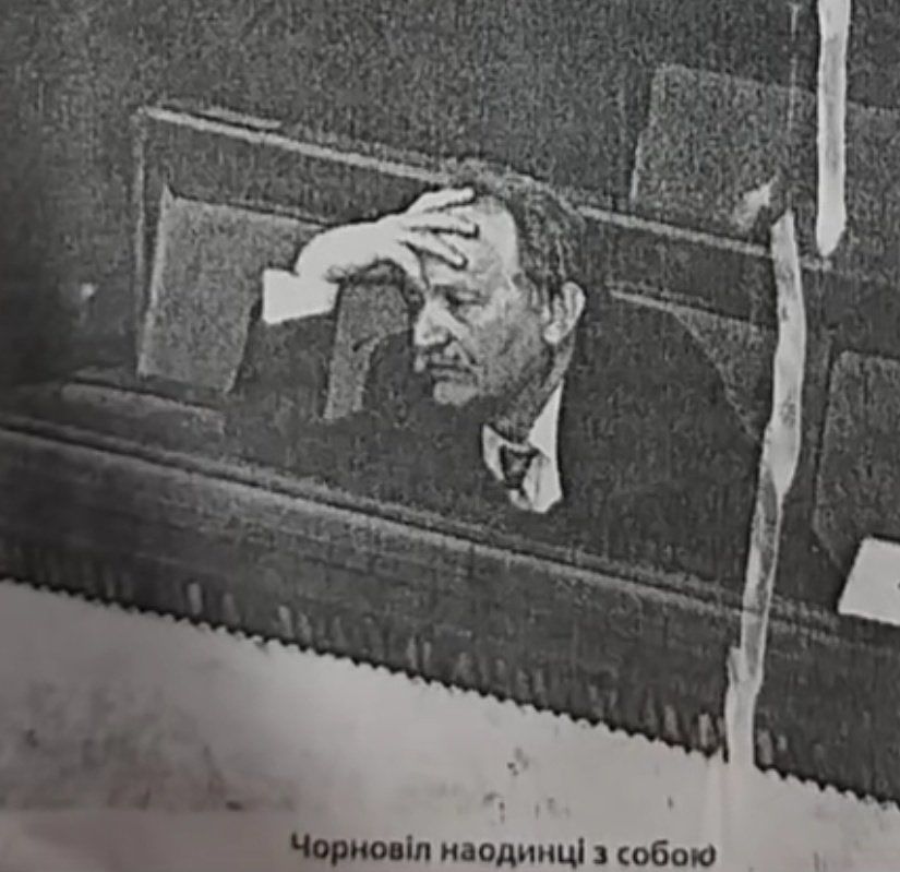 Black and white photo depicting Ukrainian politician and activist Viacheslav Chornovil sitting alone in the dark of the parliament hall with a mournful facepalm. Text under the photo reads: “Chornovil all by himself”