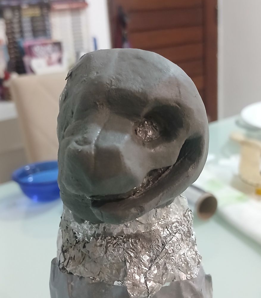 a face sculpture of a stylized tiger, only one half of the face is sculpted, and it has no eyes, teeth or nose