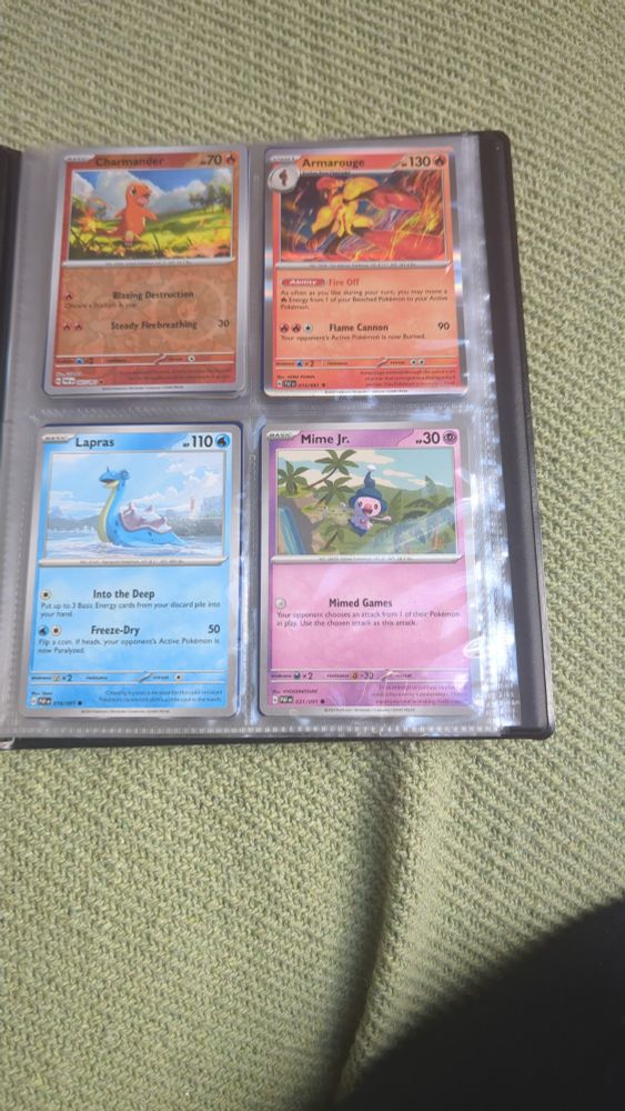 A page from a Pokémon binder showing a Charmander, Armarogue, Lapras, and Mime Jr from the Paldean Fates set.