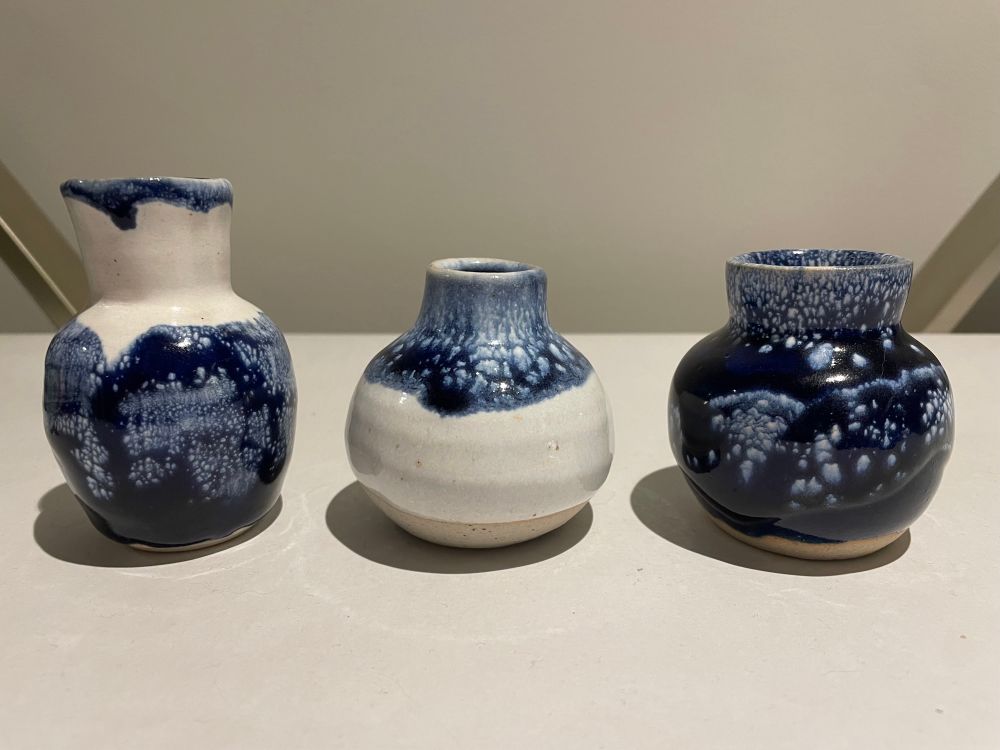 Blue on white mini pots with the white glaze spotting through the blue