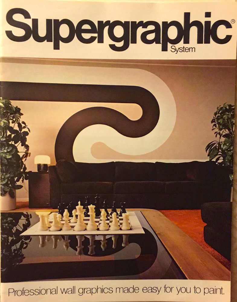 Front cover of the "Supergraphic System" manual, featuring a 1970s living room with a dark brown couch and coordinated swoopy wall stripes of dark brown and white on a beige background.