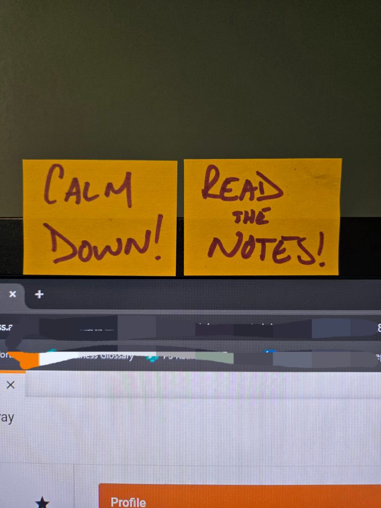 The top of a computer monitor with 2 yellow sticky notes. The first reads "CALM DOWN!" The second reads " READ THE NOTES!"