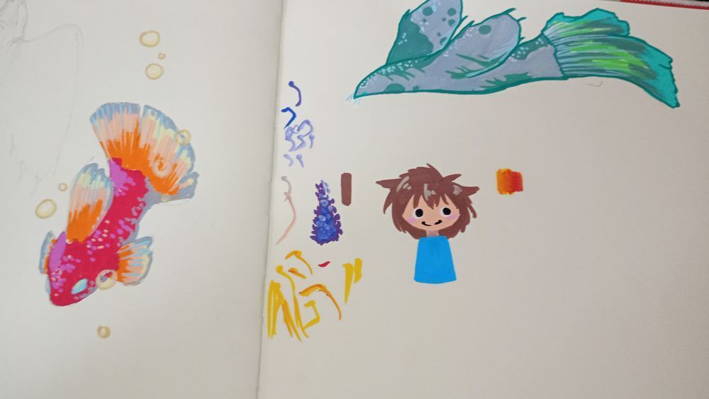 Foto of an Red fish, an seal-dragon and a doodled person. drawn with acrylicmarkers