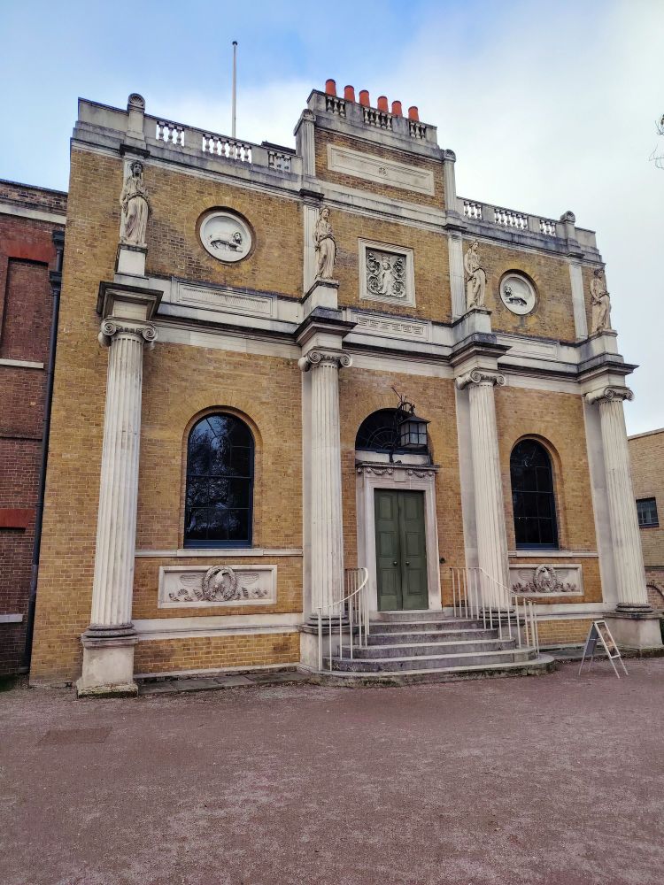 Pitzhanger Manor in Ealing. A facade of a Georgian manor house with four columns and a stone staircase leading to the central entrance.