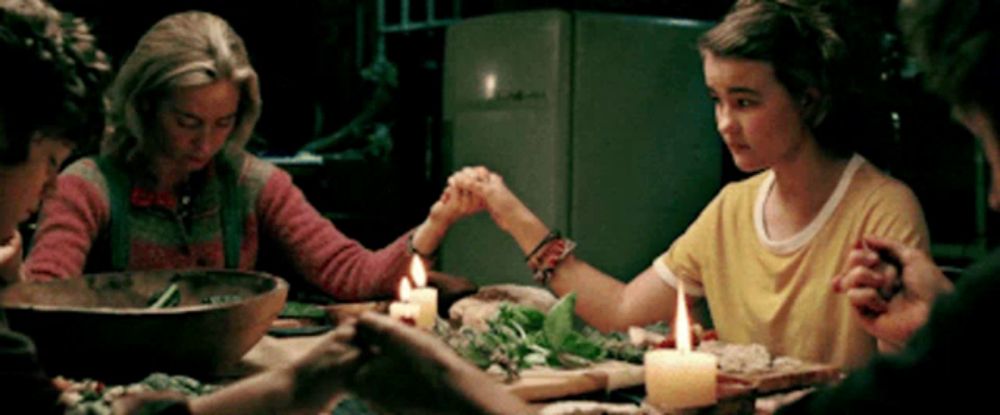 a group of people are sitting at a table with candles