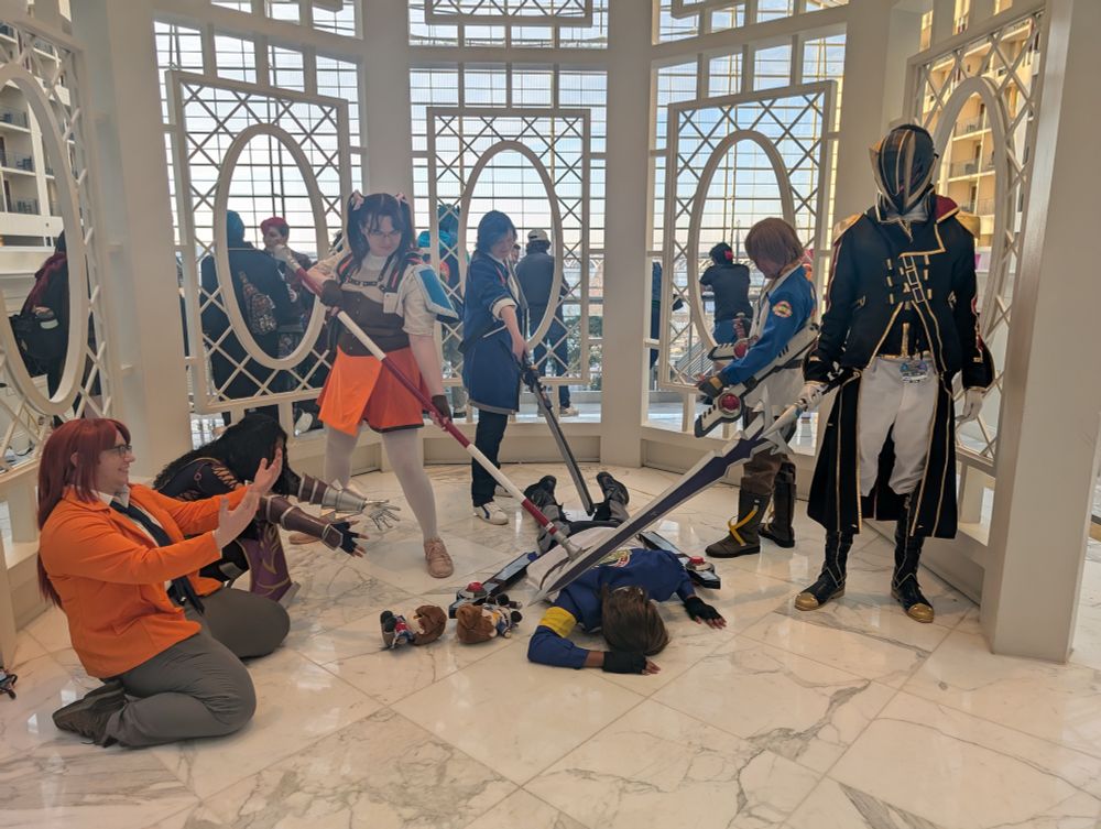 Trails cosplayers at MAGFest 2025 surrounding a collapsed Lloyd cosplayer.