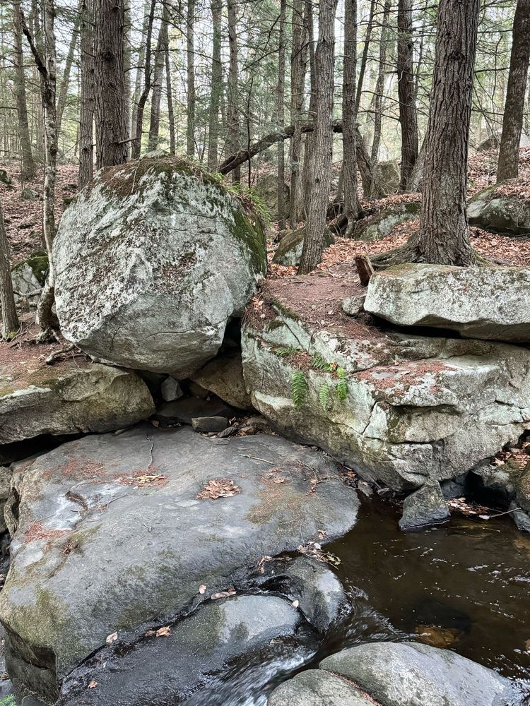 A view of very large glacial, erratic boulders stacked as the brook goes between them. You can see how the water has smoothed out some of the stones over the years.