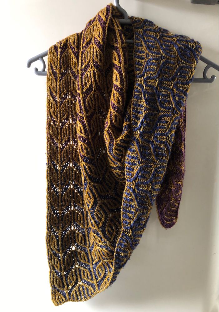 a two-colour brioche shawl being modeled by my fridge