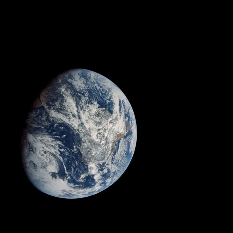 The whole Earth sunlit , blue and white but surrounded by black space. “Apollo 8. The moment humans first saw the whole Earth with their own eyes. Floating in space, the Apollo 8 crew saw the Earth at this unexpected angle, with North to the lower-left. It was taken on the way to the Moon, from a distance of 27,000 km.”  https://petapixel.com/2021/05/20/this-guy-remastered-photos-of-earth-shot-by-apollo-astronauts/