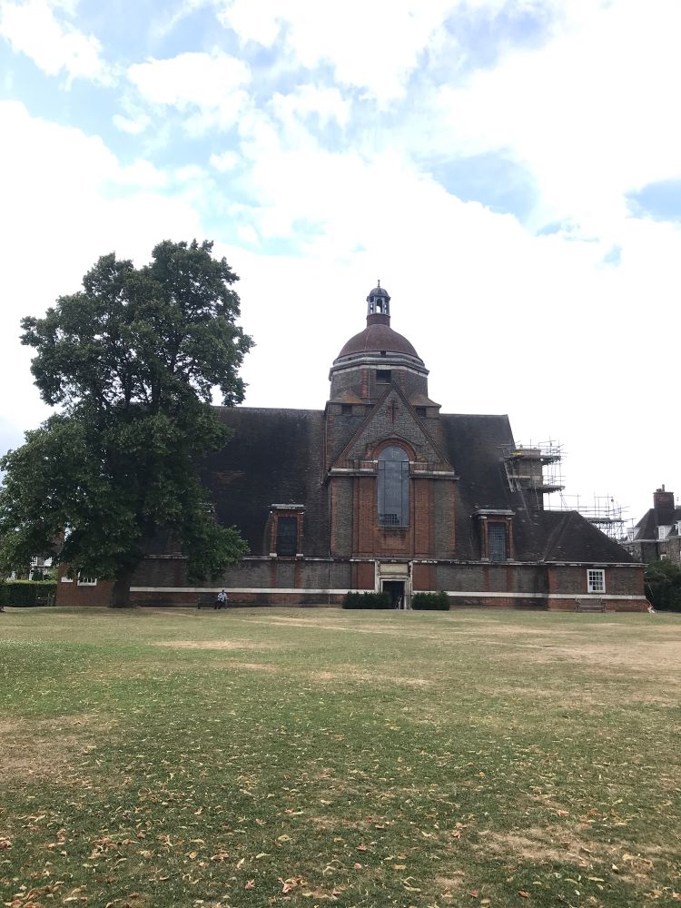 An early 20th century church with large sloping roof on a village green
