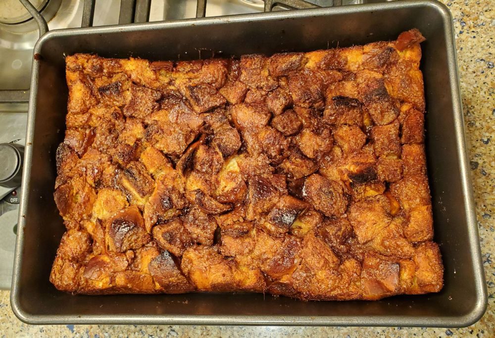a rectangular pan with a deep golden brown bread pudding-like casserole in it.